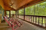 Main floor screen porch with 4 rocking chairs and swing bed